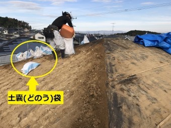 伊賀市 葺き土を土嚢に入れている写真