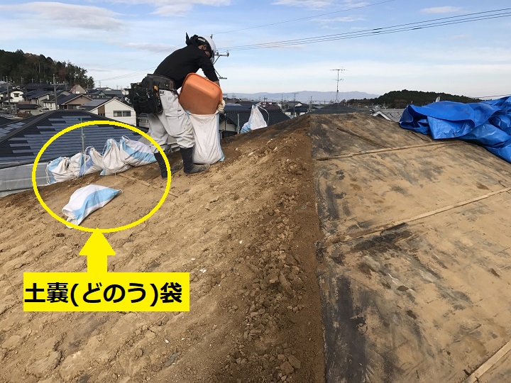 伊賀市　葺き土を土嚢に入れている写真
